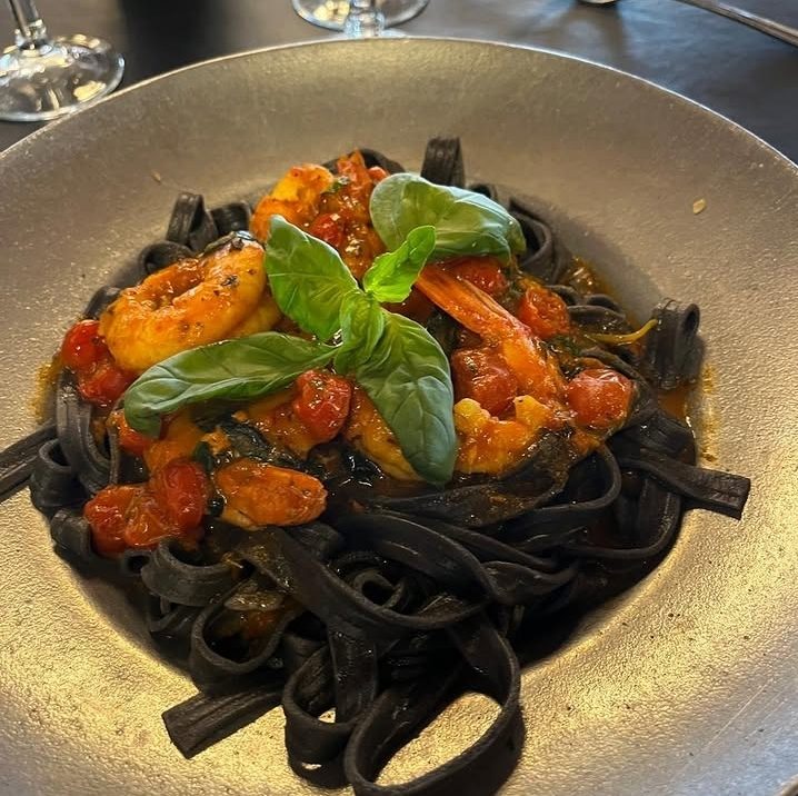 Cintas negras con langostinos, tomates cherry y albahaca